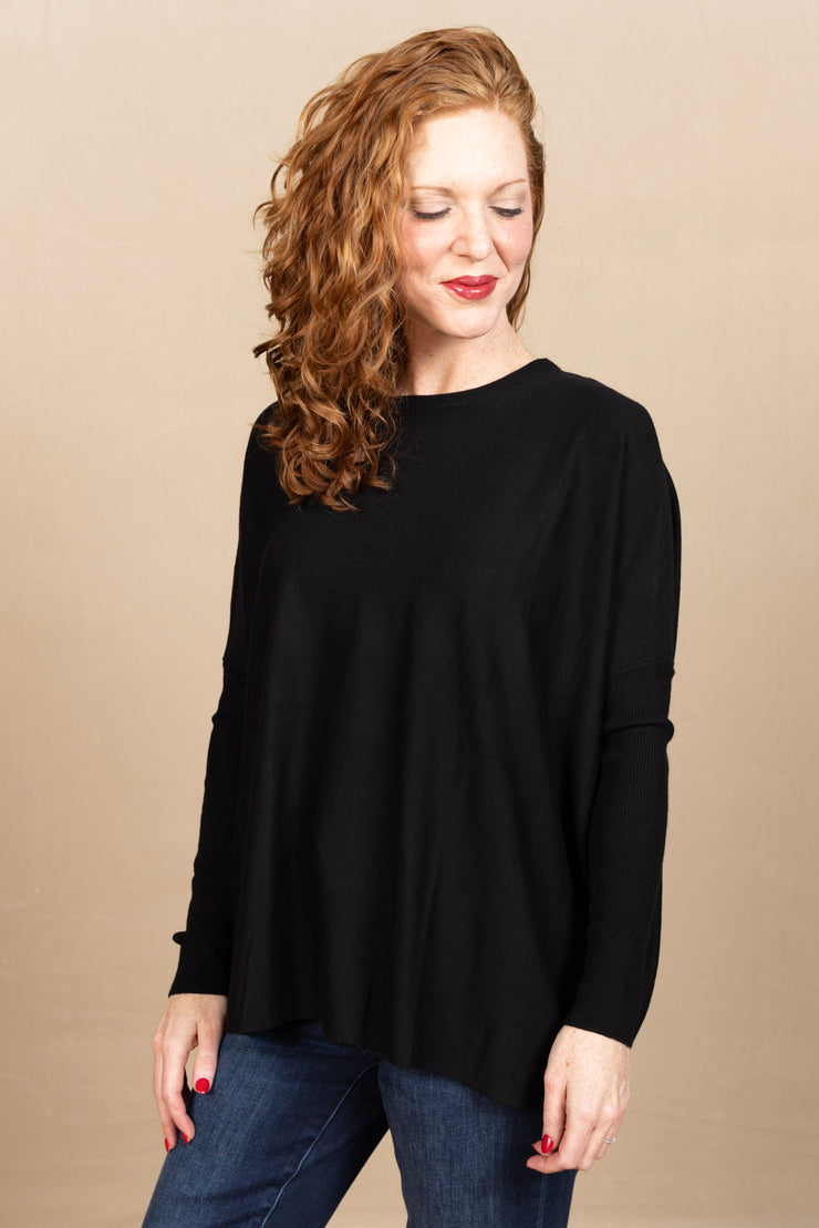 Black round neck, boxy sweater with long, ribbed sleeves.