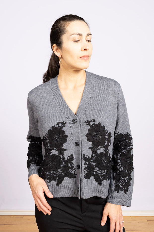 Leviane M. Grey, V-neck, black buttons, and long sleeves with wide ribbed edges