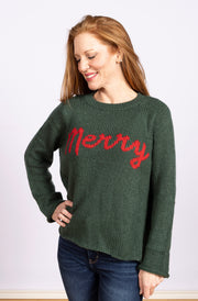 boxy pullover sweater in green with red lettering spelling Merry